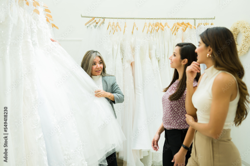Business owner of the bridal store talking to women customers Business owner of the bridal store talking to women customers