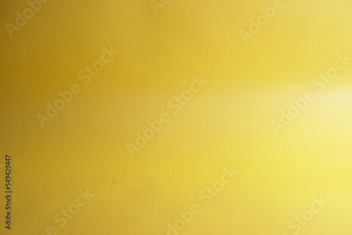 A glass kept on a yellow background with the shadow of a plant
