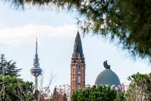 Vista de El Pirulí o Torrespaña junto a la torre del reloj de la Capilla del Cementerio de la Almudena photo