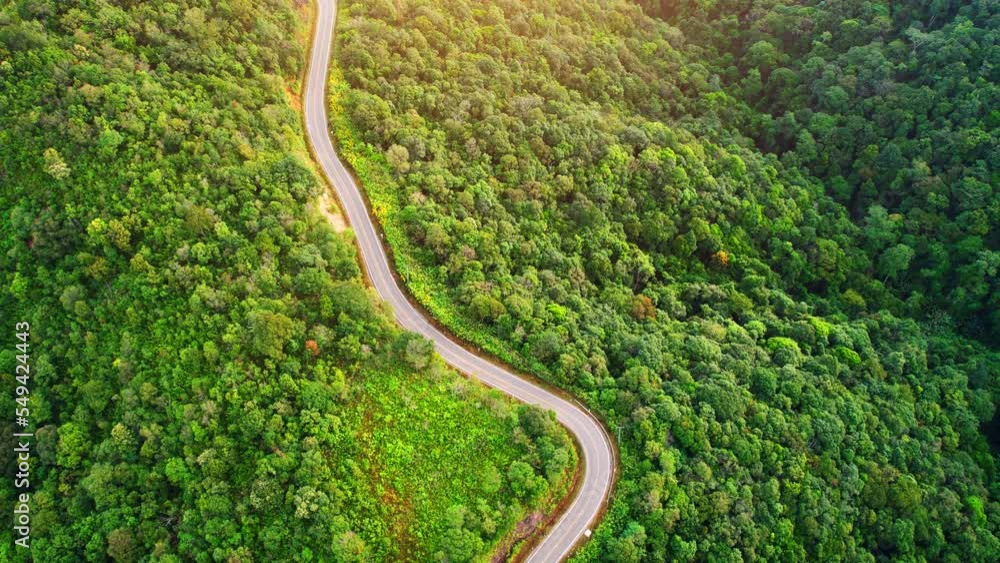 Aerial view over the mountain winding road, amazing road in the green tropical forest. Southeast asia, Thailand. tourism and travel concept. Natural the texture for background. Drone 4K video.
Aerial view over the mountain winding road, amazing road in the green tropical forest. Southeast asia, Thailand. tourism and travel concept. Natural the texture for background. Drone 4K video.