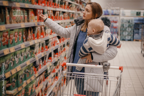 Mother and child buying in supermarket. Mom and her little son are in a grocery store shopping for food.