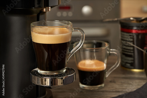 Close-up glass cup with prepared natural coffee from a coffee machine.