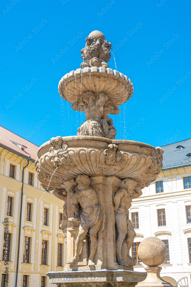 Famous fountain with sculptures at Magnificent Saint Vitus Cathedral in Prague, Czech Republic, details, blue sky.