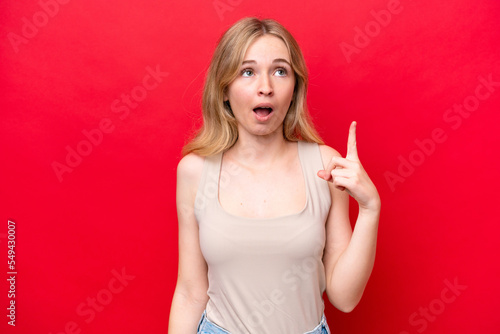 Young English woman isolated on red background thinking an idea pointing the finger up © luismolinero