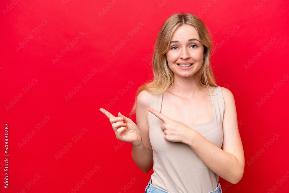 Naklejka premium Young English woman isolated on red background frightened and pointing to the side