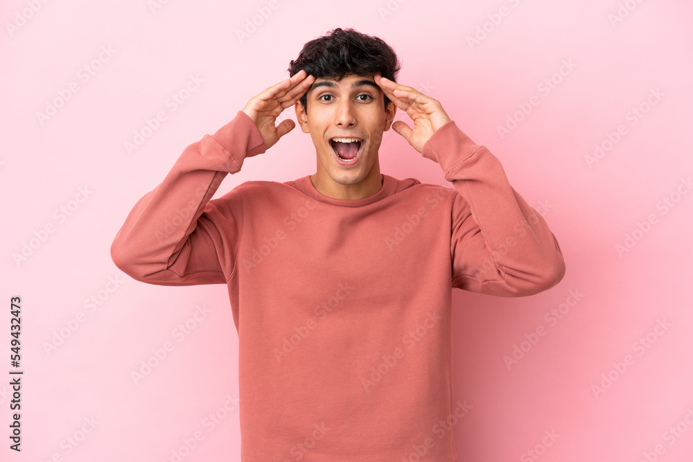 Young Argentinian man isolated on pink background with surprise expression Young Argentinian man isolated on pink background with surprise expression