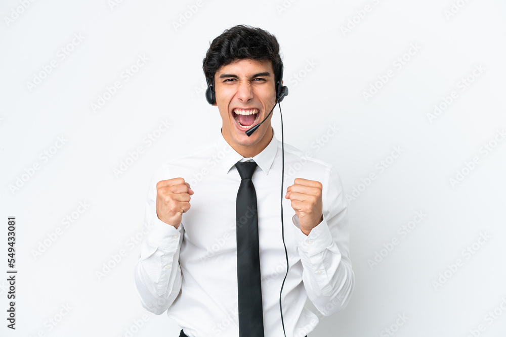 Telemarketer man working with a headset isolated on white background celebrating a victory in winner position Telemarketer man working with a headset isolated on white background celebrating a victory in winner position