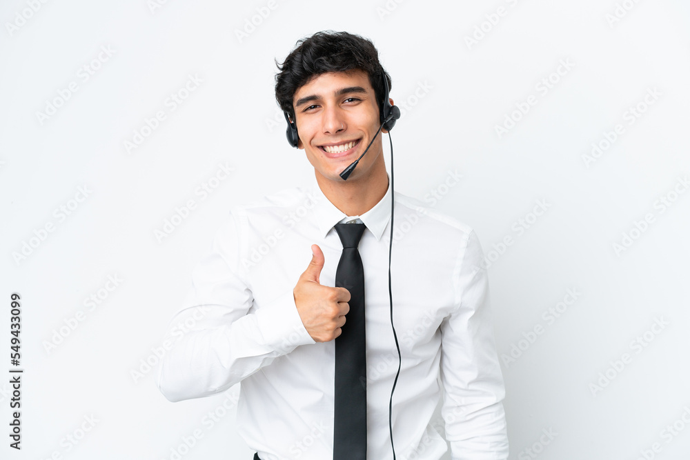 Telemarketer man working with a headset isolated on white background giving a thumbs up gesture Telemarketer man working with a headset isolated on white background giving a thumbs up gesture