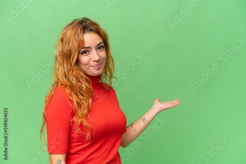 Young caucasian woman isolated on green screen chroma key background extending hands to the side for inviting to come