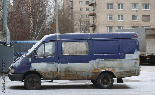 Old rusty blue minivan parked on the road, Iskrovsky Prospekt, St. Petersburg, Russia, November 2022