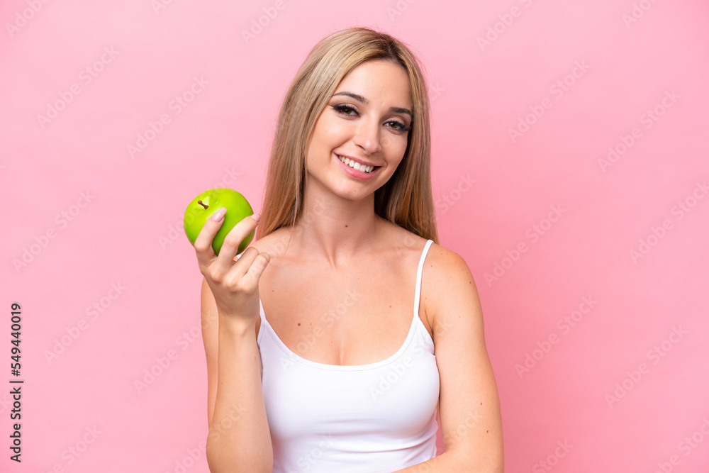Pretty blonde woman isolated on pink background with an apple Pretty blonde woman isolated on pink background with an apple