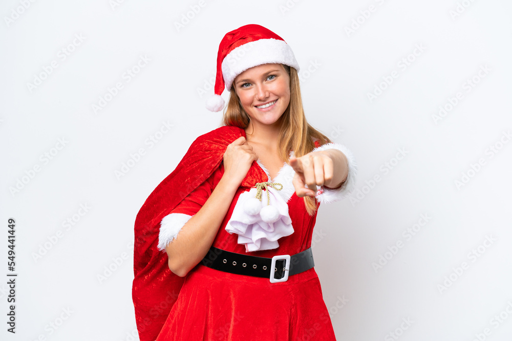 Young caucasian woman dressed as mama noel holding Christmas sack isolated on white background points finger at you with a confident expression Young caucasian woman dressed as mama noel holding Christmas sack isolated on white background points finger at you with a confident expression