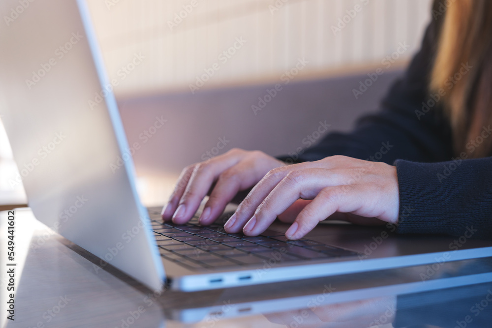 Closeup image of a woman working and typing on laptop computer keyboard Closeup image of a woman working and typing on laptop computer keyboard