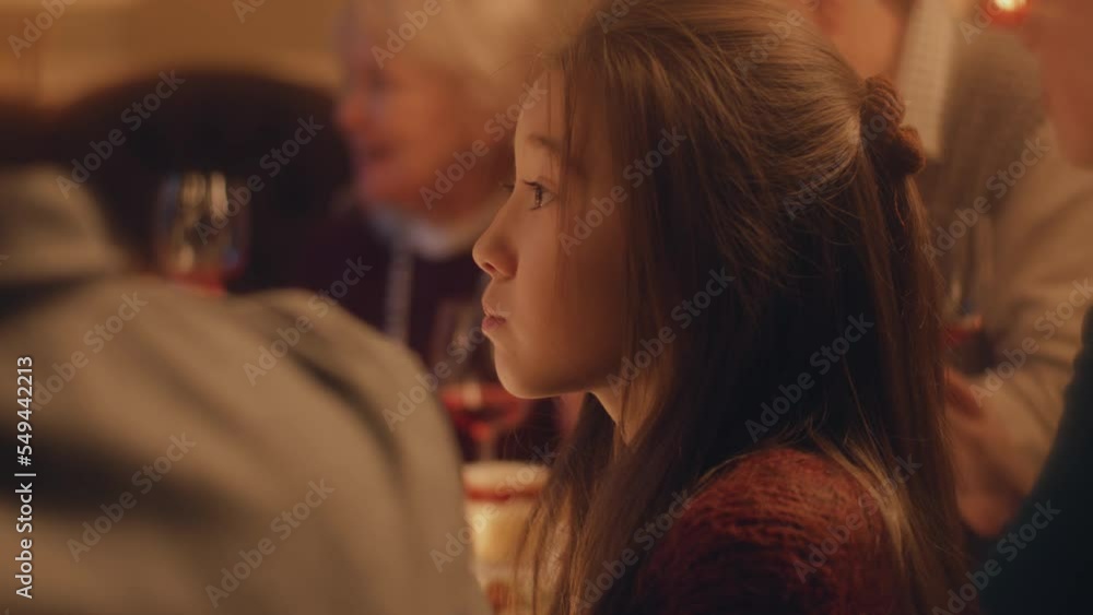 Close-up shot of young asian girl. She eats and drinks juice. Family celebrating Christmas, New Year or Thanksgiving Day. Served holiday table. Warm atmosphere of family Christmas dinner at home. Close-up shot of young asian girl. She eats and drinks juice. Family celebrating Christmas, New Year or Thanksgiving Day. Served holiday table. Warm atmosphere of family Christmas dinner at home.