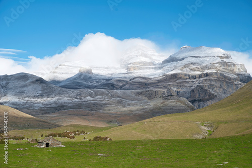 Old shelter in the canyon of Añisclo with the mountains in the background. The three Sorros": Monte Perdido, Cilindro and Añisclo. With the first snowfall of November 2022. Mallata Carduso