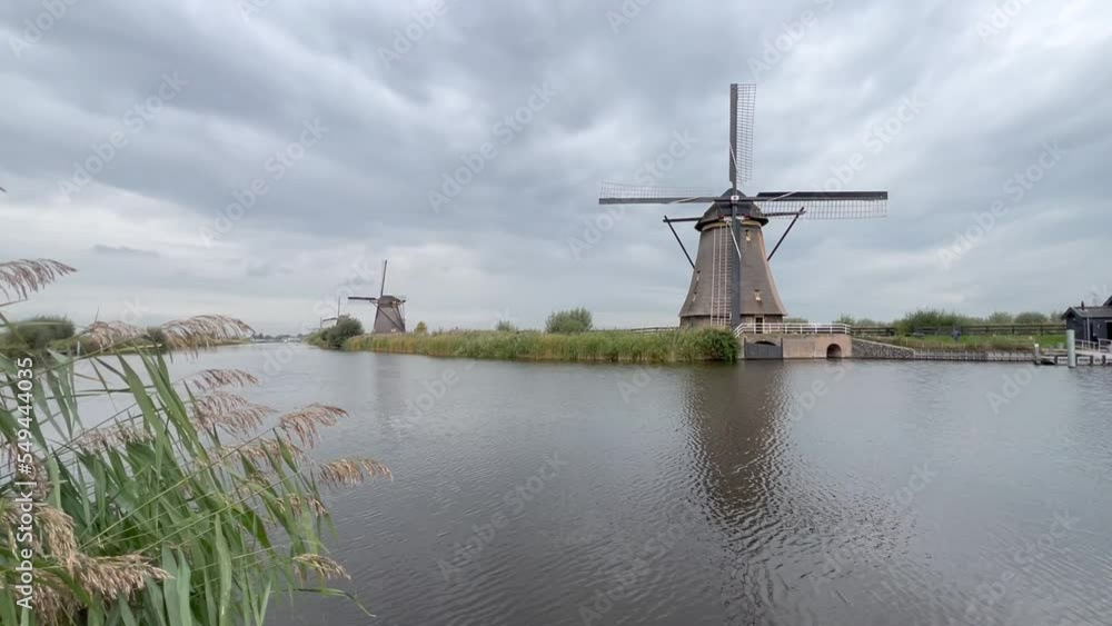 Scenic, panoramic view of Kinderdijk landscape with traditional wooden Dutch windmills. Motion of water in canal, polder. Kinderdijk is UNESCO world heritage site. Kinderdijk, Netherlands Scenic, panoramic view of Kinderdijk landscape with traditional wooden Dutch windmills. Motion of water in canal, polder. Kinderdijk is UNESCO world heritage site. Kinderdijk, Netherlands