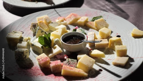 Assorted of Italian and French cheeses with an author's fashionable mustard sauce on a festive table restaurant in a beautiful sunlight. Preparation for a banquet, wedding or corporate party. photo