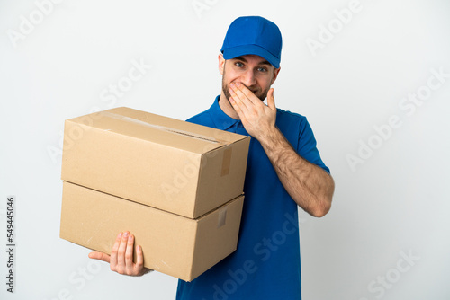 Delivery man over isolated white background happy and smiling covering mouth with hand © luismolinero