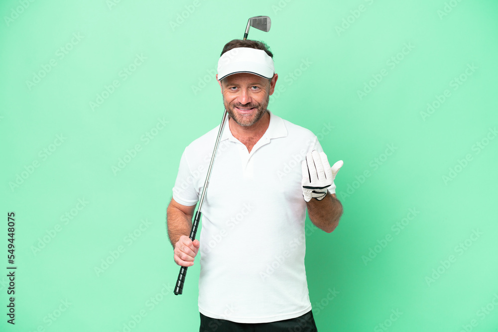 Middle age caucasian man isolated on green background playing golf and doing coming gesture Middle age caucasian man isolated on green background playing golf and doing coming gesture