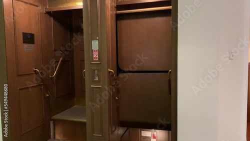 Motion of wooden vintage open, no door paternoster lift at Prague's New city hall.  Tourists very often comes to see this rare elevator technology. Prague, Czech Republic
