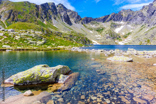 Rocks and stones in water of beautiful lake in Hinczowa valley on sunny summer day, High Tatra Mountains, Slovakia photo