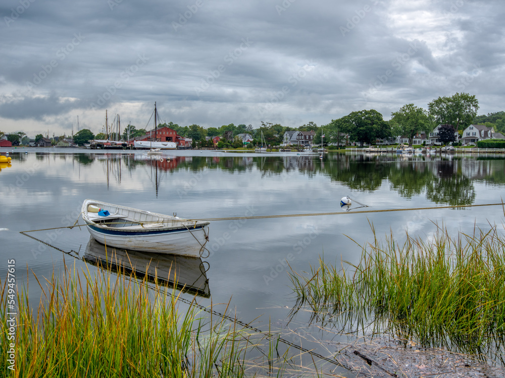 Wooden rowboat with the village of Mystic, CT in the background.
