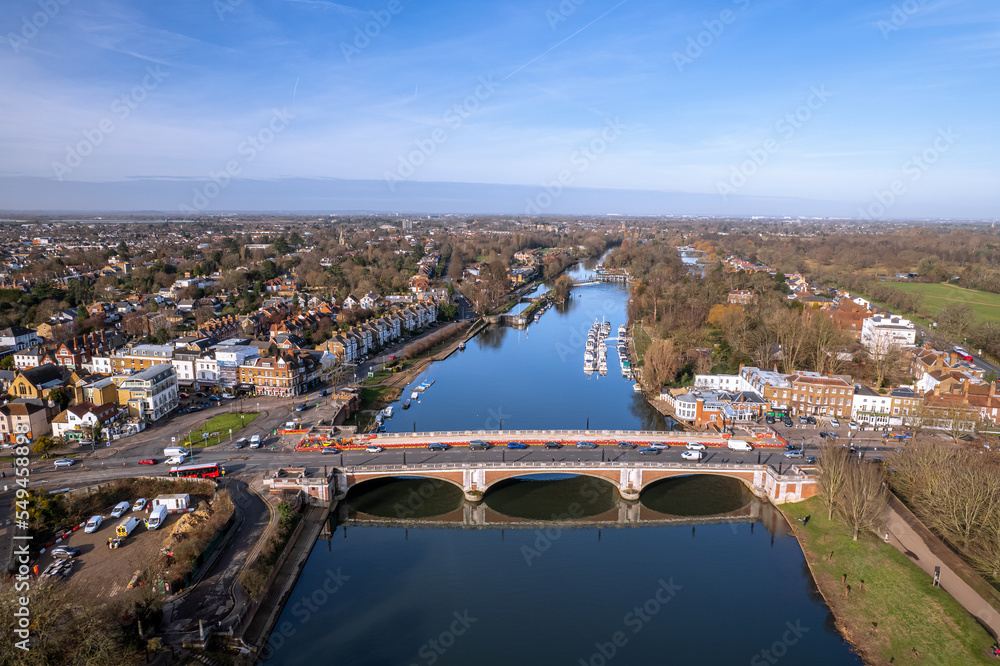 The drone aerial view of Hampton Court bridge and Thames river. Hampton Court Bridge crosses the River Thames in England between Hampton, London and East Molesey, Surrey.