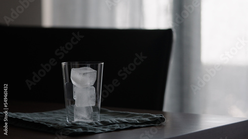 man making iced coffee with milk in thumbler glass on walnut table photo