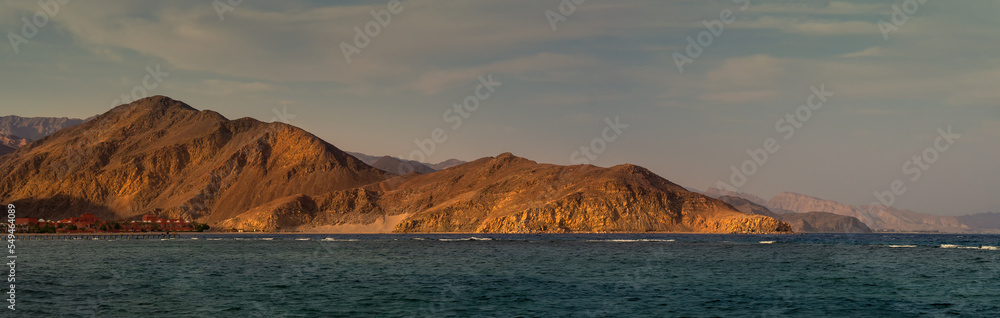 Panoramic landscape of Taba with mountain ranges and beautiful cloudy sky at sunset.