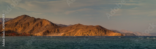 Panoramic landscape of Taba with mountain ranges and beautiful cloudy sky at sunset.