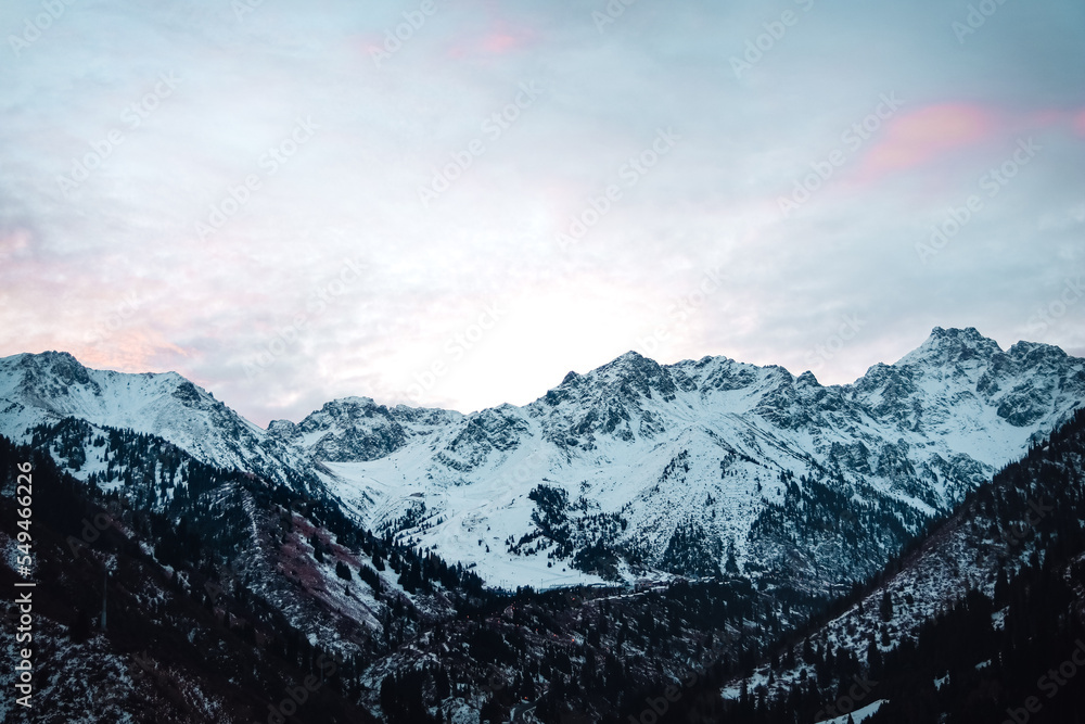 beautiful snow-capped big mountains at dawn with scarlet color clouds