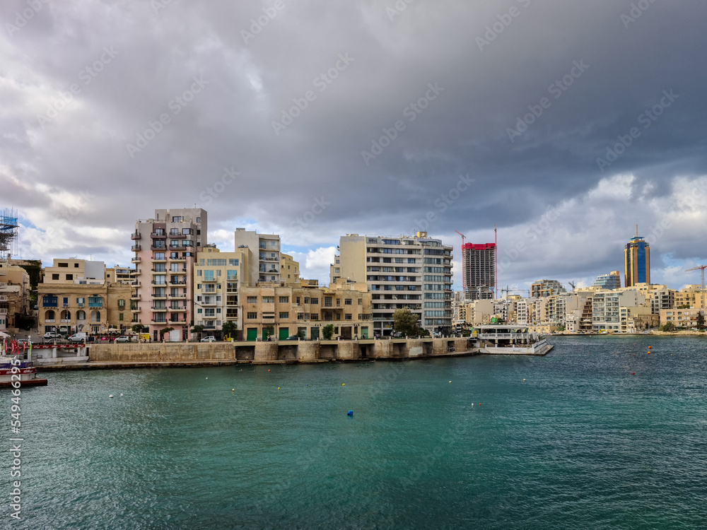 Dark clouds over the buildings at Balluta Bay and Spinola Bay both in the town San Giljan (St. Julian's) in Malta. Dark clouds over the buildings at Balluta Bay and Spinola Bay both in the town San Giljan (St. Julian's) in Malta.