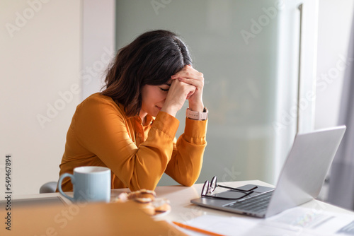 Remote Work Burnout. Depressed Young Arab Woman Sitting At Desk With Laptop