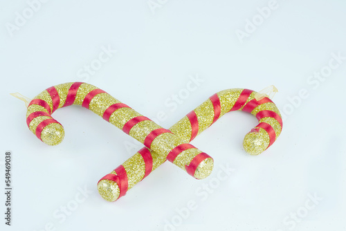 Gold and red candy canes with glitter on white background
