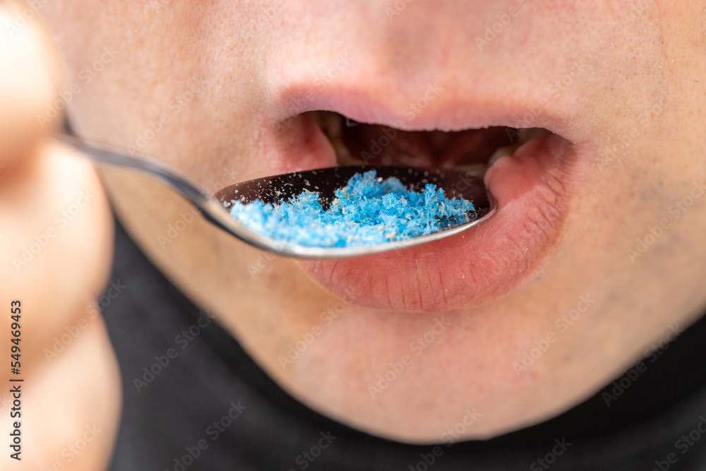 Microplastic in food, Environment and health concept, Person putting a spoon with plastic particles in his mouth