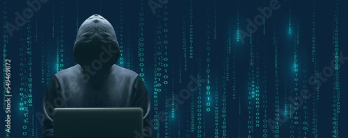 Silhouette décalée sur la gauche du cybercriminel devant son écran d'ordinateur portable sur fond de données binaires cyan