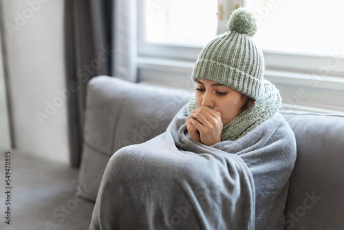 Obraz na płótnie Young Woman Feeling Cold At Home, Sitting On Couch Covered In Blanket
