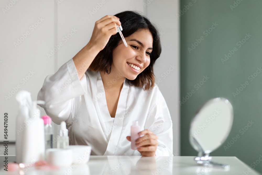 Pretty arab young woman using facial serum at home Pretty arab young woman using facial serum at home
