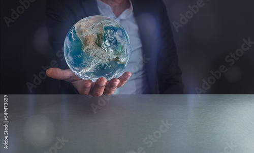 Earth day or mother eath day ,Human hand holding blue earth or mother eath day on grey background , save earth conceptel ,elements of this image furnished by NASA , copy space . photo