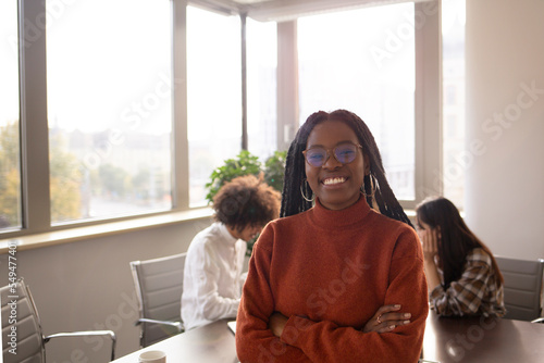Black girl in foreground is taking a break in the office
