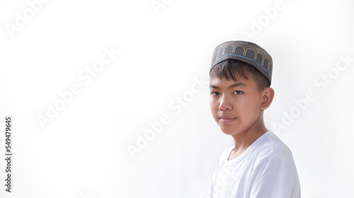 Portrait young southeast asian islamic or muslim boy in white shirt and hat, isolated on white, soft and selective focus.
