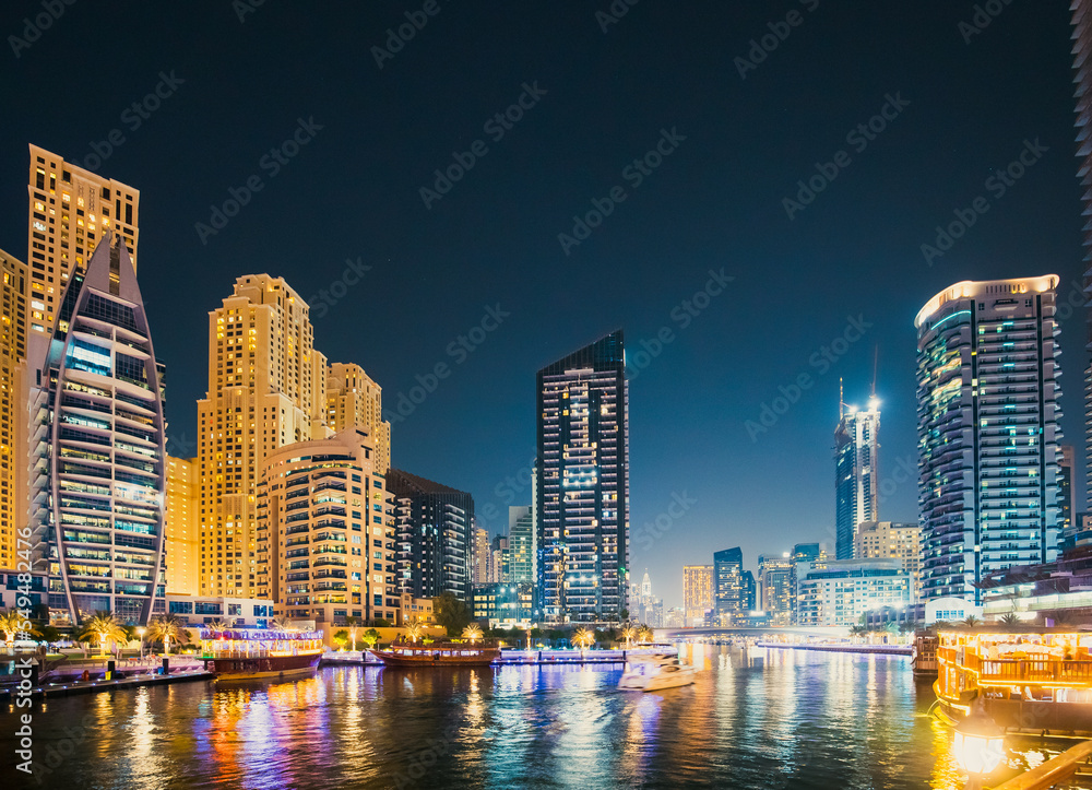 Night view of skyscraper of residential district in Dubai Marina And Tourist Boat, Sightseeing Boat Sailing On Dubai Marina.