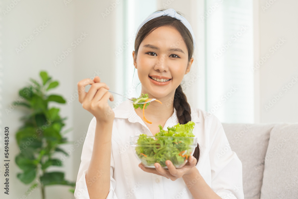 Diet, Dieting pretty attractive asian young woman, girl use fork at lettuce on mix vegetables, green salad bowl, eat food is low fat to good body. Nutritionist female, Weight loss for healthy person. Diet, Dieting pretty attractive asian young woman, girl use fork at lettuce on mix vegetables, green salad bowl, eat food is low fat to good body. Nutritionist female, Weight loss for healthy person.