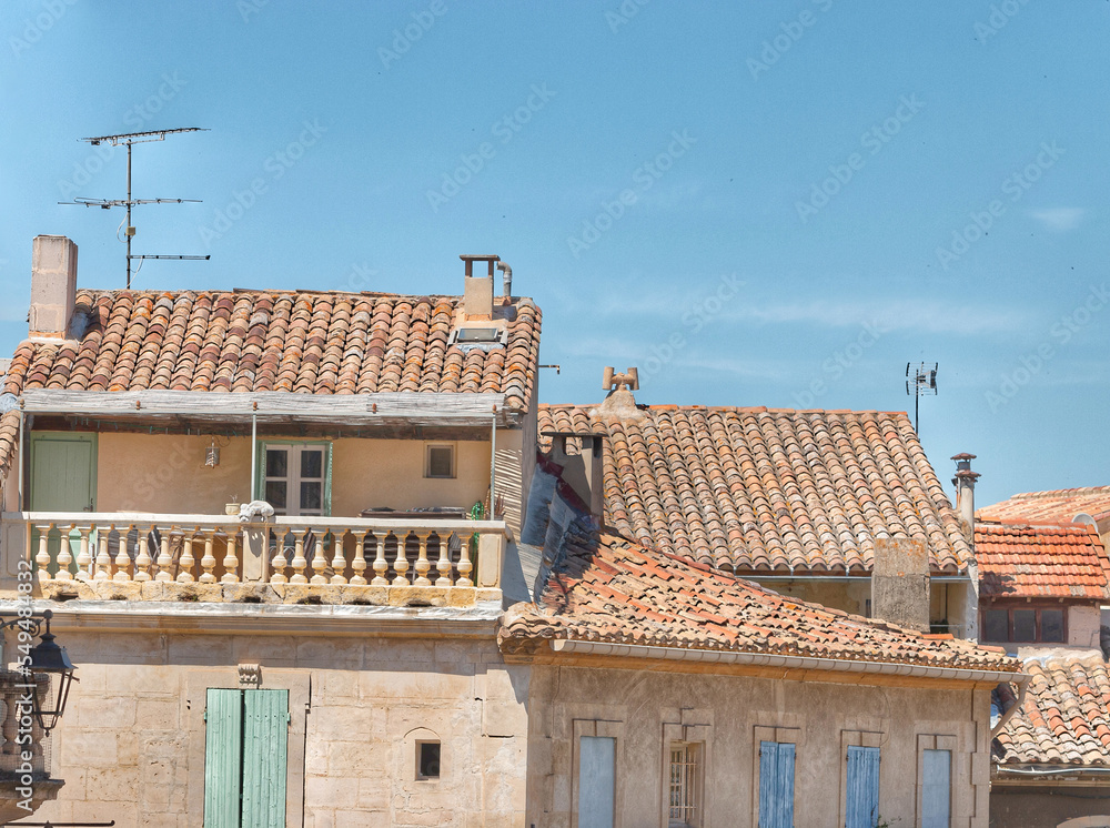 House roofs, building facades in a typical provence town, Arles, France. Houses with orange tiled roofs. Green shutters. House roofs, building facades in a typical provence town, Arles, France. Houses with orange tiled roofs. Green shutters.