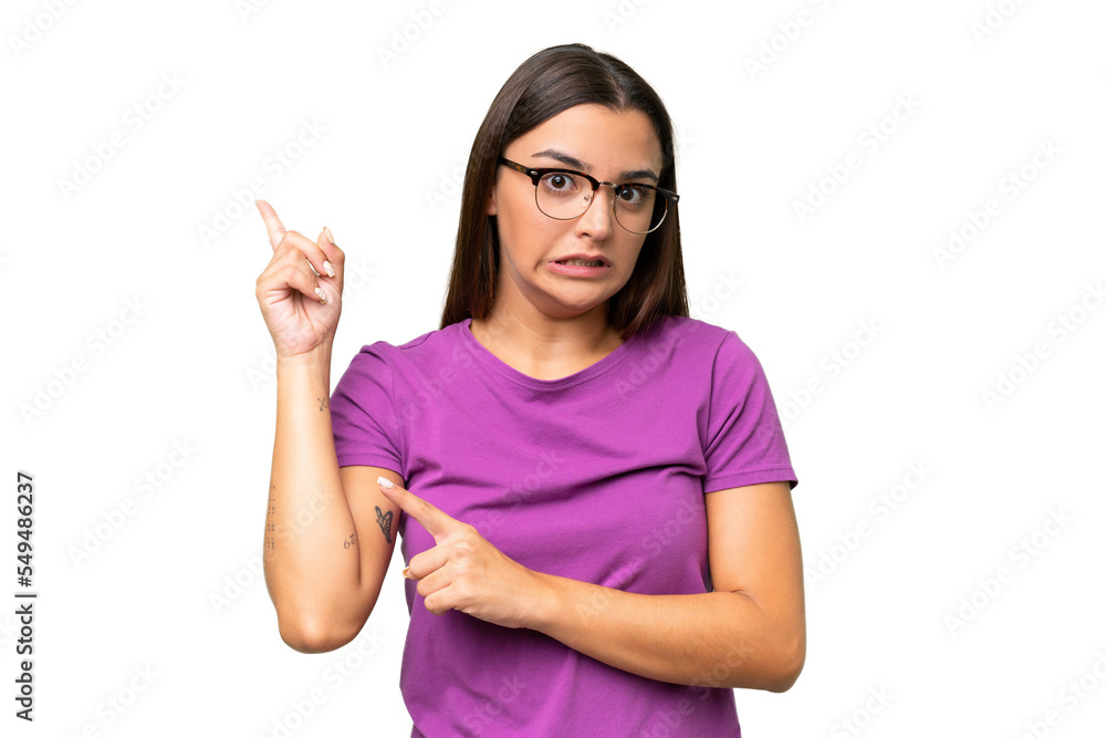 Young caucasian woman isolated on green chroma background frightened and pointing to the side Young caucasian woman isolated on green chroma background frightened and pointing to the side