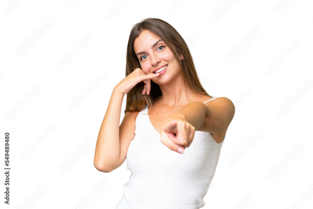 Young pretty woman over isolated background making phone gesture and pointing front Young pretty woman over isolated background making phone gesture and pointing front