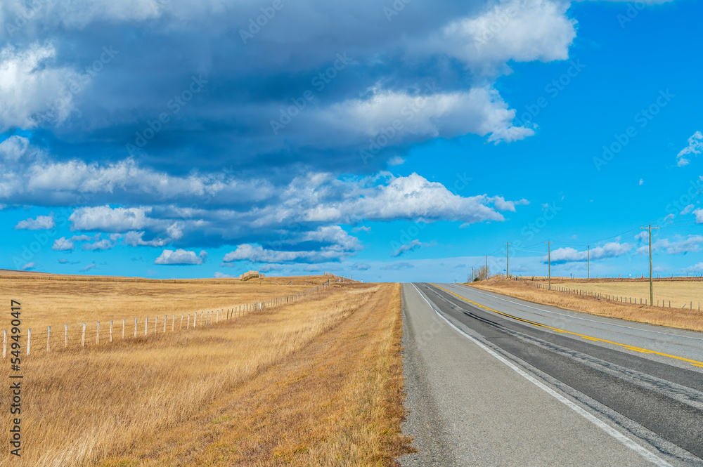 Early morning panorama view with the moon still visible, meadow with beautiful clouds and a road Early morning panorama view with the moon still visible, meadow with beautiful clouds and a road