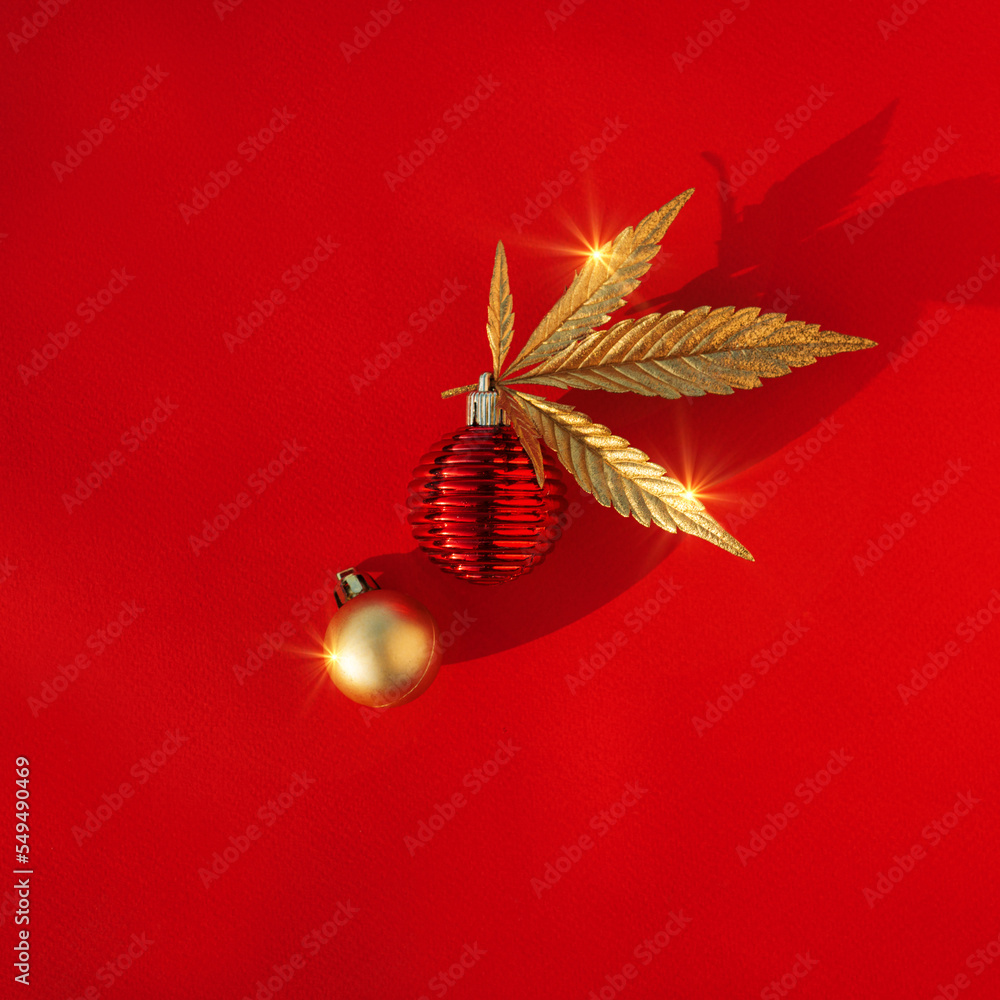 Fototapeta premium Abstract red christmas background with golden cannabis, marijuana leaf and festive decor.