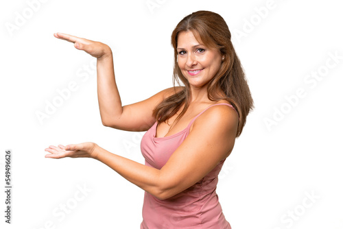 Middle-aged caucasian woman over isolated background holding copyspace to insert an ad