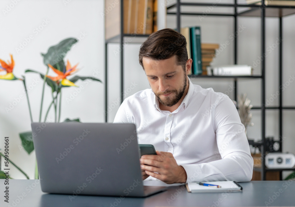 Focused bearded man entrepreneur working while sitting in the office